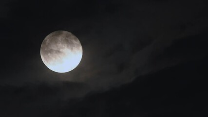 experience the full moon rise through drifting clouds in stunning 4k time lapse on a dark night sky