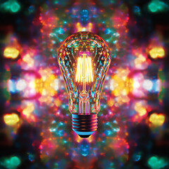 Poster - illuminated light bulb with vibrant colorful bokeh background, symbolizing creativity, ideas, and en