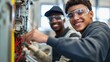 © felix_brönnimann - Young technicians working together on electrical equipment, smiling and engaged in hands-on training at a vocational school or workshop for future careers.