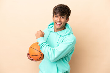 Wall Mural - Handsome young basketball player man isolated on ocher background celebrating a victory