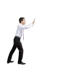 Fototapete - A man in formal attire, appearing to push an invisible object with both hands, isolated on a white background. Concept of effort or resistance