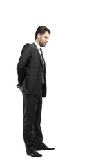 Poster - A businessman wearing a formal suit, standing with hands behind his back, side profile, isolated on a white background. Professional concept