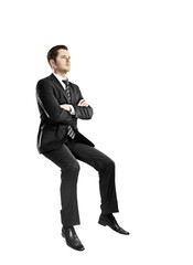 Poster - A man in a suit and tie sits with arms crossed, looking confident, on a white background. Professional attire and confident posture concept