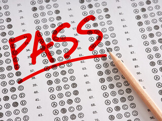 Wall Mural - The word Pass written on a sheet of test exam paper with pencil.