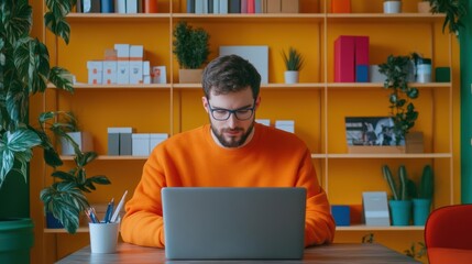 Aufkleber - Focused Man in Bright Orange Sweater Working on Laptop in Cozy Indoor Space Surrounded by Warm Lighting and Inviting Home Office Decor Elements