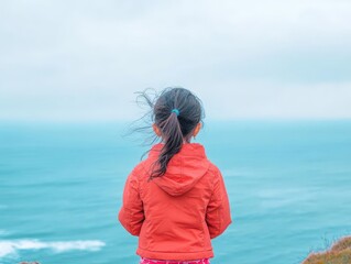 Aufkleber - Innocent Little Girl Gazing Contemplatively at Expansive Ocean Waves Under Clear Blue Sky Evoking Feelings of Wonder and Adventure at the Shoreline
