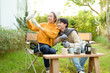 © tonefotografia - Two Friends Enjoying a Cozy Outdoor Moment While Taking a Selfie in a Sunny Garden