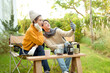 © tonefotografia - Two Friends Enjoying a Cozy Outdoor Moment While Taking a Selfie in a Sunny Garden