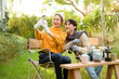 © tonefotografia - Two Friends Enjoying a Cozy Outdoor Moment While Taking a Selfie in a Sunny Garden