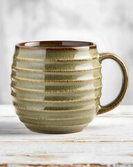 Canvas Print - Rustic green ceramic mug with textured stripes on a wooden table