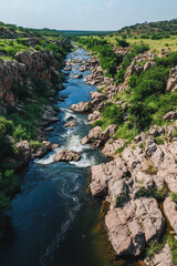 Poster - A high-resolution drone shot of a powerful river winding through rocky terrain, surrounded by lush greenery and hills, showcasing the beauty of nature and rugged landscapes.