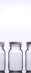 Wall Mural - Three glass jars with silver lids on a white background, minimalistic