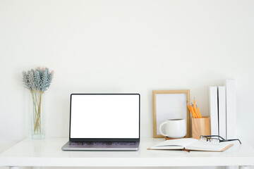 Fototapete - Office desk with a laptop, open notebook, and coffee mug, complemented by decorative items such as a wooden photo frame, lavender in a glass vase, and a pencil holder.