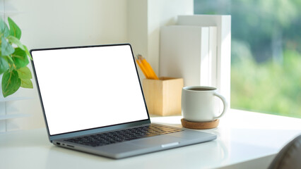 Fototapete - Workspace featuring a laptop, a cup of coffee, and neatly arranged stationery, complemented by a potted plant for a refreshing and inspiring environment.