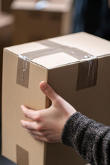 Aufkleber - Person holding a cardboard box in a warehouse setting