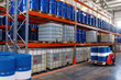 © Grispb - Chemical warehouse. Barrels with flammability symbol. Forklift in warehouse area. Oil barrels are stored on racks. Warehouse hangar inside. Interior industrial chemical storage facility.