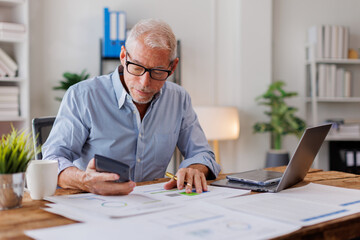 Wall Mural - Mature Caucasian man working at office with documents on his desk, doing planning analyzing the financial report, business plan investment, finance analysis concept	