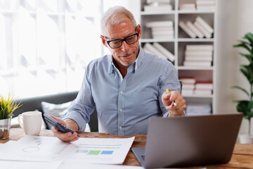 Wall Mural - Mature Caucasian man working at office with documents on his desk, doing planning analyzing the financial report, business plan investment, finance analysis concept	