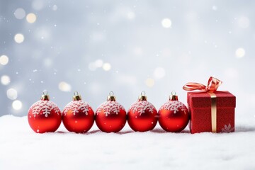 Poster - Red christmas ornaments and a gift box resting on snow create a festive holiday scene