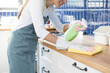 © KMPZZZ - Cleanliness service concept, housekeeping asian young woman working chore cleaning on counter at home, wearing glove using rag rub wiping dirty in kitchen. Housework or chores and clean up, cleaner.