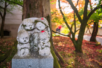  Jizo statue with red maple leaf at Autumn garden, Eikan-do, Kyoto