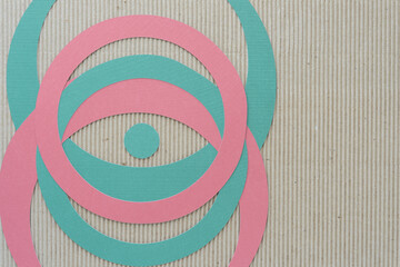 Poster - green and pink machine-cut paper rings and dot on brown corrugated paper