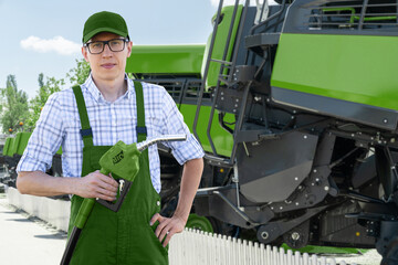 Wall Mural - Man with biofuel refueling nozzle next to agricultural machines