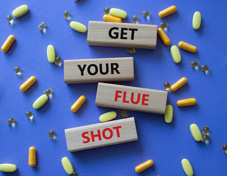 Get your Flue Shot symbol. Concept word Get your Flue Shot on wooden blocks. Beautiful pink background with pills. Medicine Get your Flue Shot concept. Copy space