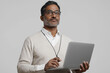 © DLV - Indian man holding laptop. Entrepreneur startup. Remote freelance. A dynamic Indian teacher explaining with a laptop in a classroom setting.