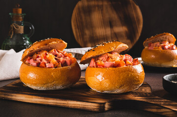 Wall Mural - Baked burgers with sausages, tomatoes, cheese and egg on a board on a table