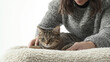 © sabyna75 - Professional pet sitter gently brushing a relaxed cat in cozy indoor setting