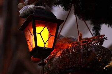 Poster - A lantern hangs from a decorated Christmas tree with a lit candle inside.