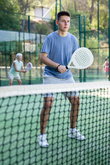 Wall Mural - Young teenage padel tennis player training on court. Boy using racket to hit ball.