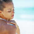 © Alliance - Young woman applying sun screen creme