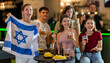 © JackF - Group of friends cheer together for their favorite Israeli team in a beer bar