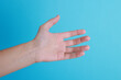 © New Africa - Woman with visible hand veins on light blue background, closeup