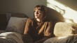 © Chayanin Wongpracha - woman sitting on bed in sunlight