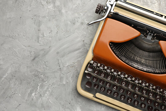 Vintage typewriter on grey background, top view. Space for text