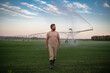© Volodymyr - Farmer standing in a grassy field near green farm with irrigation channels. A man harvesting vegetables on a farm. Irrigation system. Middle aged farmer inspecting a harvest-ready field.