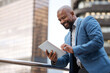 © Malambo20/peopleimages.com - Happy, online and businessman with tablet, balcony and trader with app for market research and outdoor. Digital, corporate and info for investment, employee and planning with website and typing