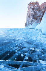 Wall Mural - Beautiful winter landscape of frozen Baikal Lake. View of famous cape Sagan-Khushun called Three Brothers and blue ice with cracks, bubbles and ice hummocks near Olkhon Island. Winter travels, outdoor