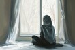 © MUHAMMAD ANIS - Woman in Hijab Sitting by a Window with Soft Light