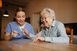 © Halfpoint - Friendly caregiver and elderly patient working on puzzle together, having fun.