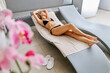 © Westend61 - Blond woman resting on lounge chair at spa