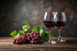 © Urenus Photos - Two glasses of rich red wine alongside a cluster of ripe red grapes on a rustic wooden surface.
