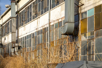 Wall Mural - old, abandoned and ruined building in the city. ventilation channels on the wall. broken windows and panes by vandals.