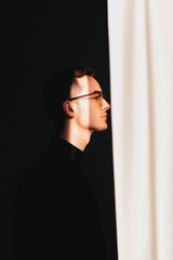 Poster - Minimalist Silhouette Profile Young Male Engineer in Dark Studio Backdrop with Soft Light Curtains - Industrial Tech Content and Design Innovation for Modern Business