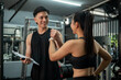 © bongkarn - A cheerful Asian male fitness instructor is holding a client hand to cheer up after discussing.