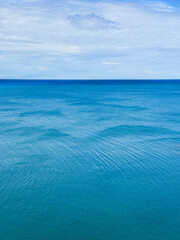 Wall Mural - blue sea calm rippled water and cloudy sky.