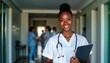 © Vadym - Smiling young black female doctor in white scrubs stands in hospital corridor holding tablet folder. Medical pro looks friendly, confident. Modern healthcare scene suggests advanced tech integration